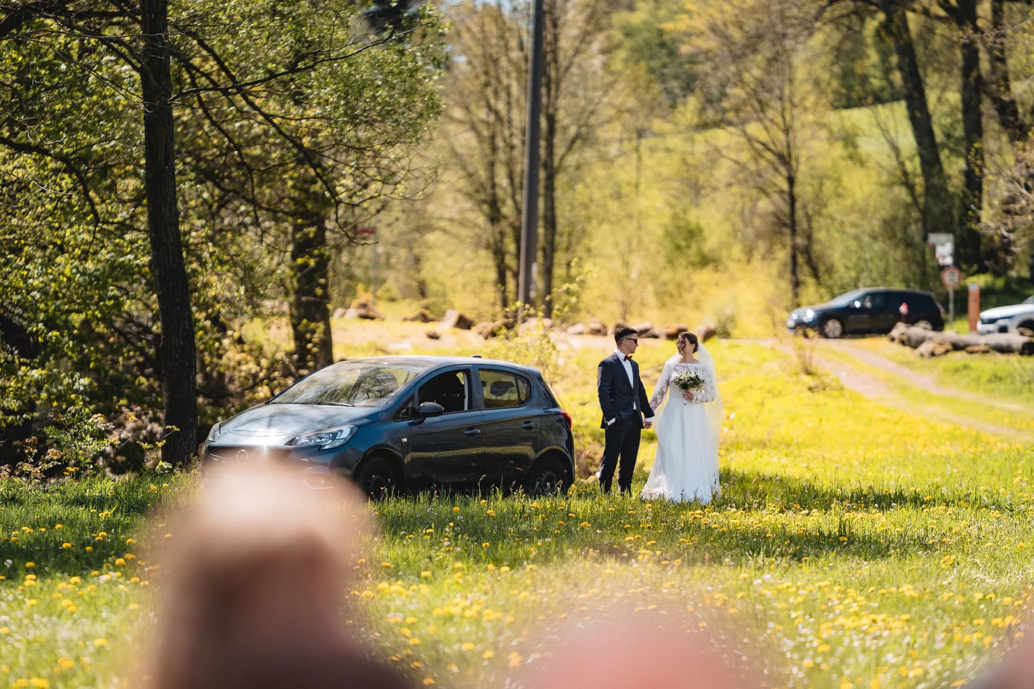 Brautpaar Stefanie und Ralf spaziert entspannt über eine blühende Frühlingswiese an der Ulstermühle in der Rhön.