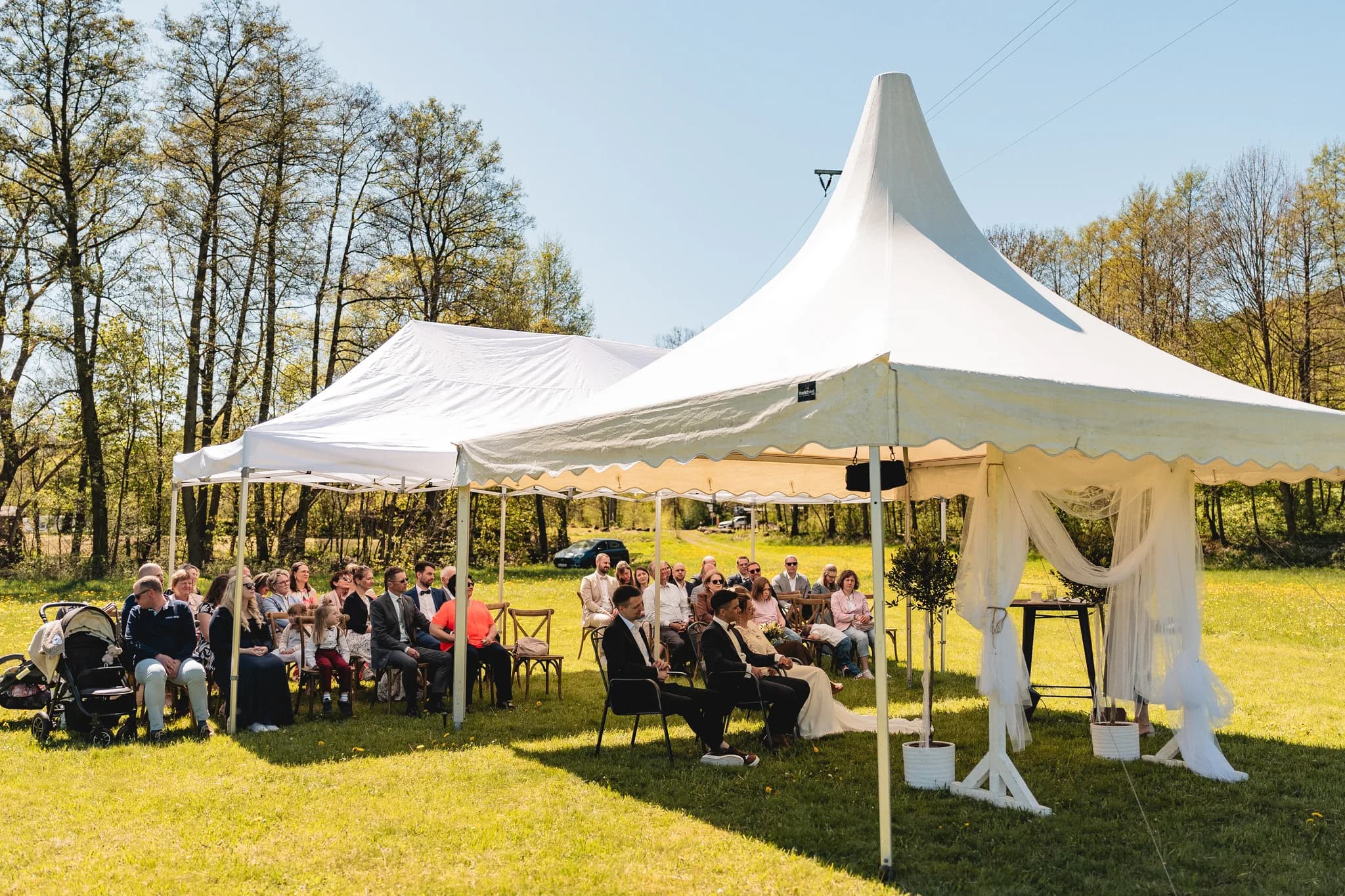 Stefanie und Ralf bei ihrer entspannten freien Trauung unter weißen Pavillons auf einer grünen Wiese in der Rhön.