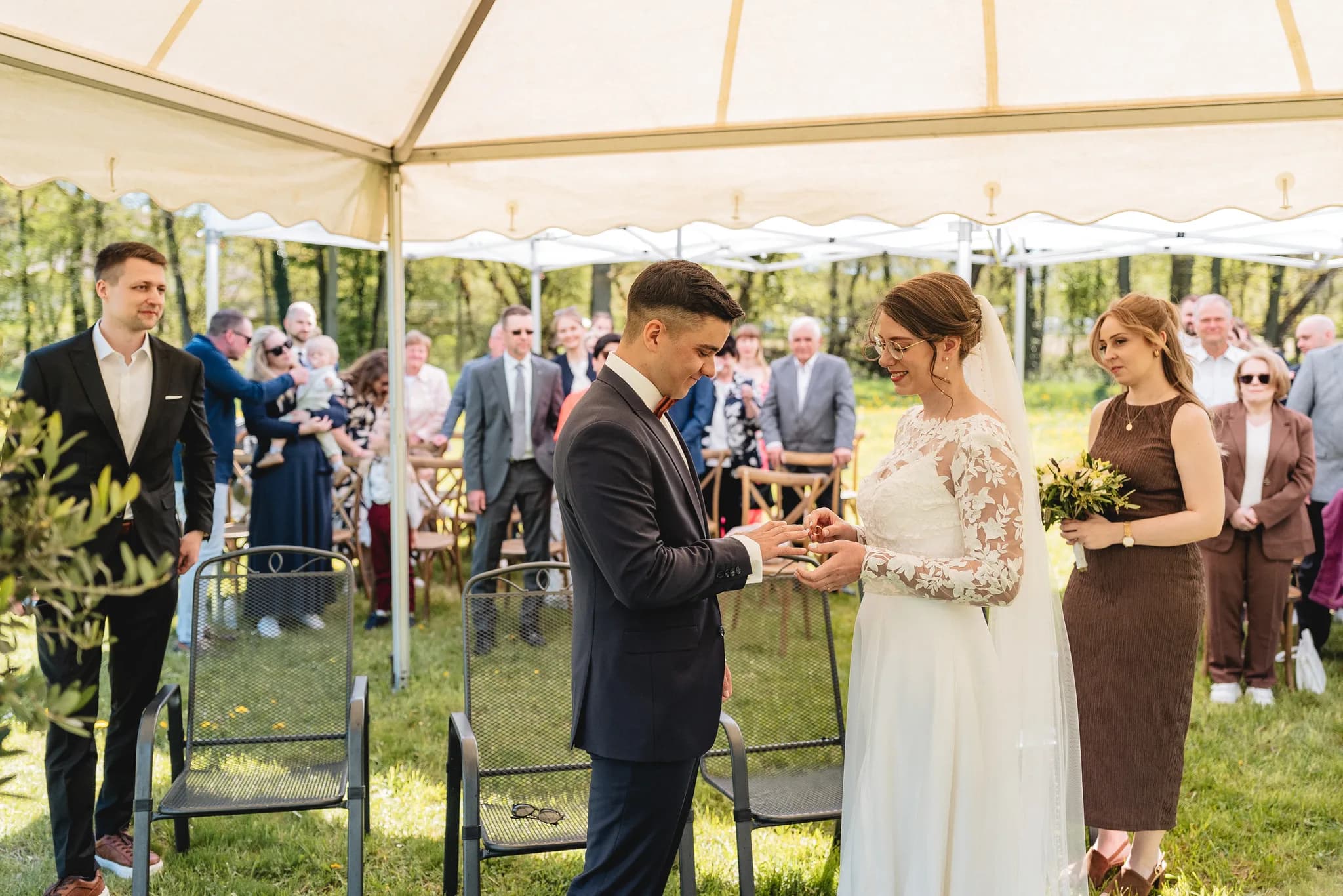 Stefanie und Ralf tauschen während ihrer entspannten freien Trauung auf einer grünen Wiese in der Rhön die Eheringe.