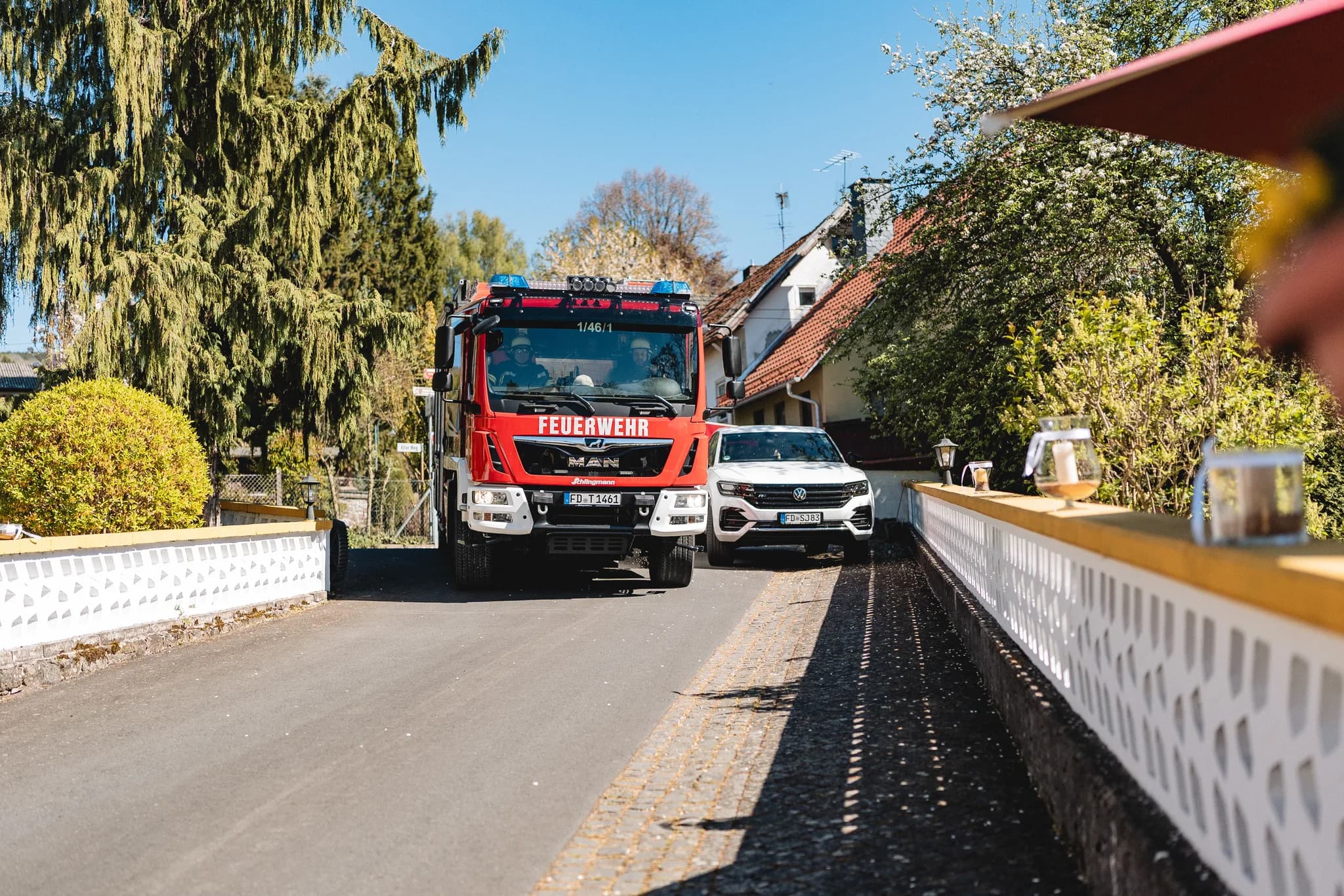 Ein rotes Feuerwehrauto fährt bei strahlendem Sonnenschein an der Ulstermühle zum Hochzeitsgelände von Stefanie und Ralf.