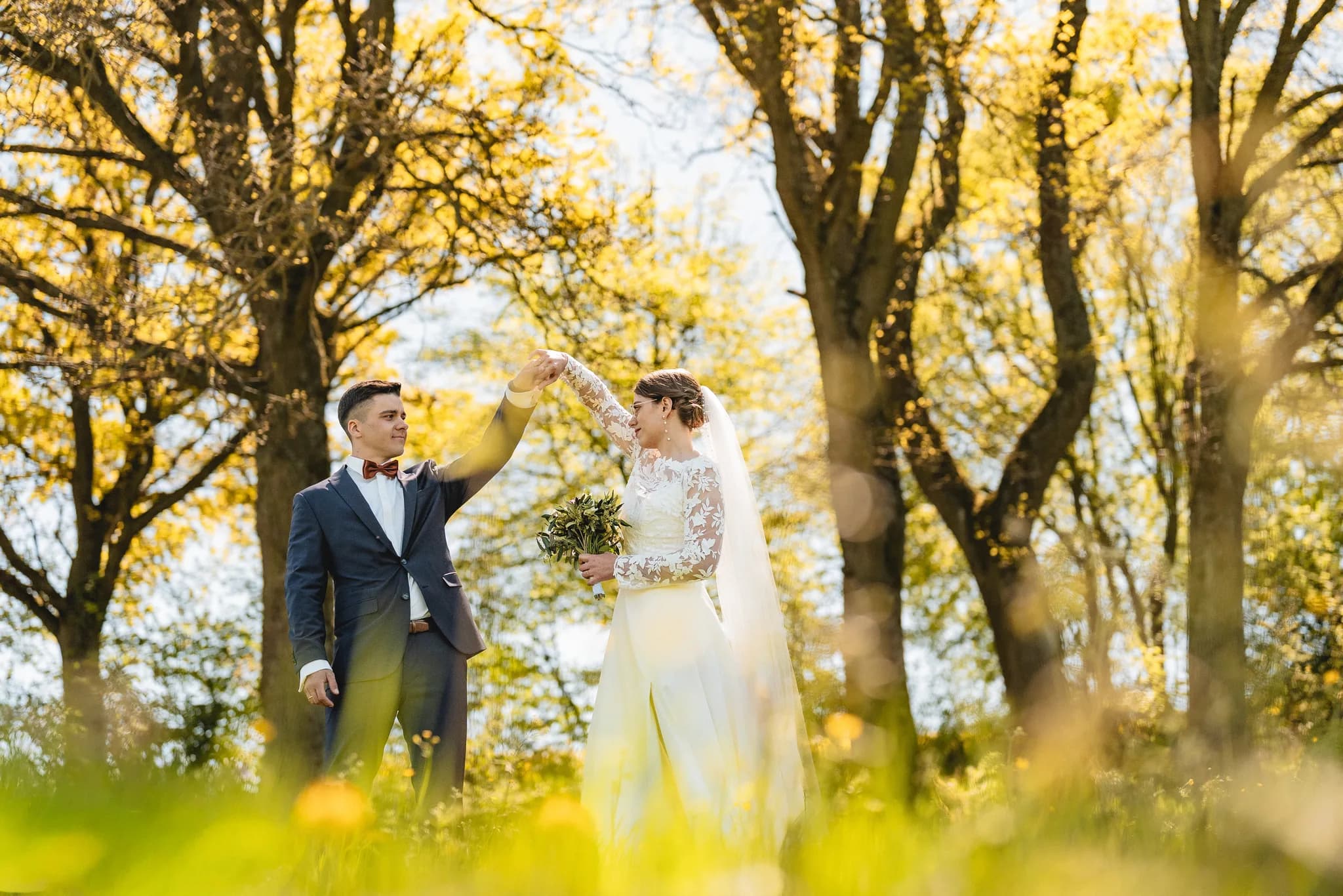 Stefanie und Ralf tanzen bei strahlendem Maiwetter gemeinsam auf einer sonnigen Wiese inmitten der grünen Rhön.
