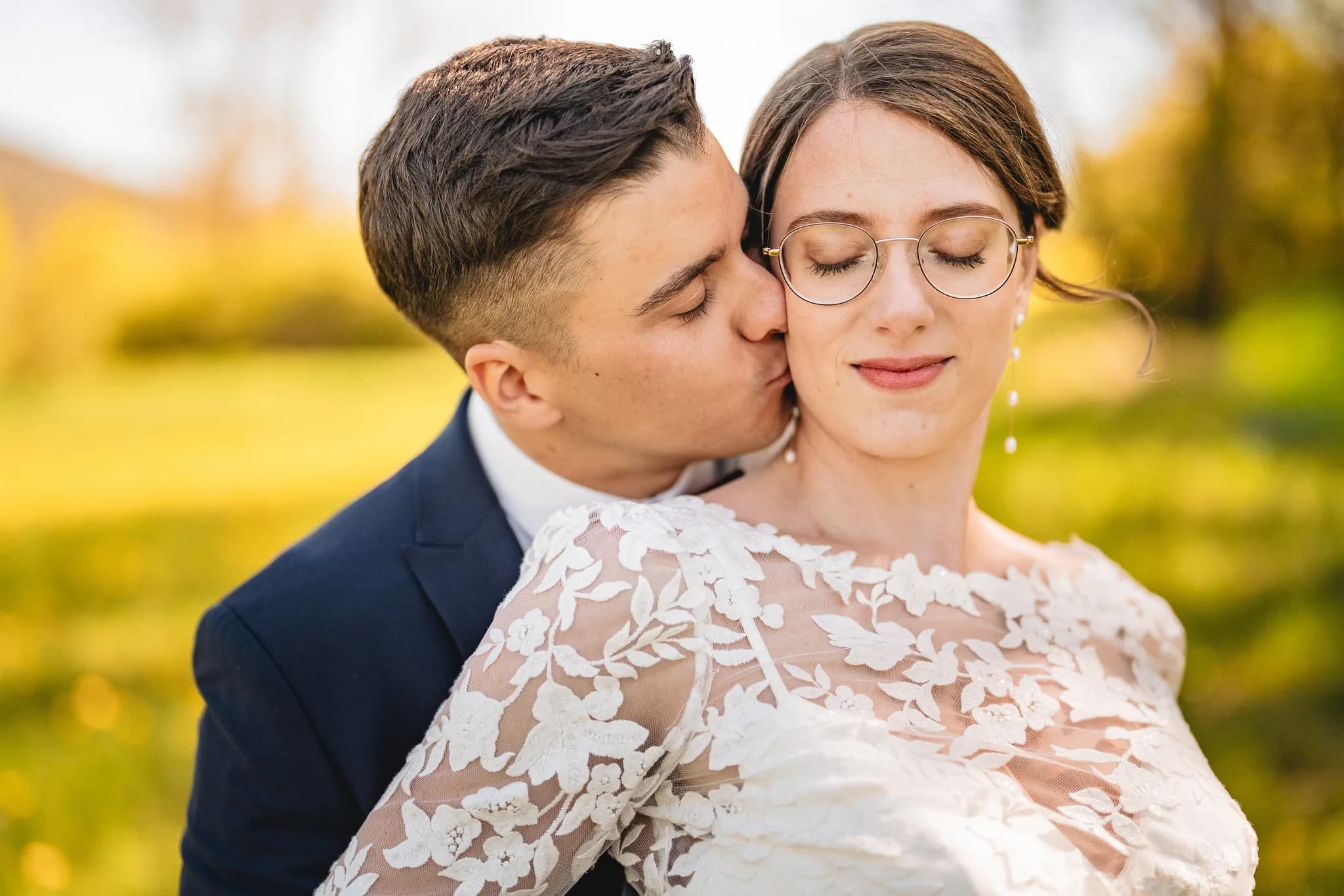Brautpaar Stefanie und Ralf bei einer innigen Umarmung während ihrer entspannten Hochzeit auf der Wiese in der Rhön.