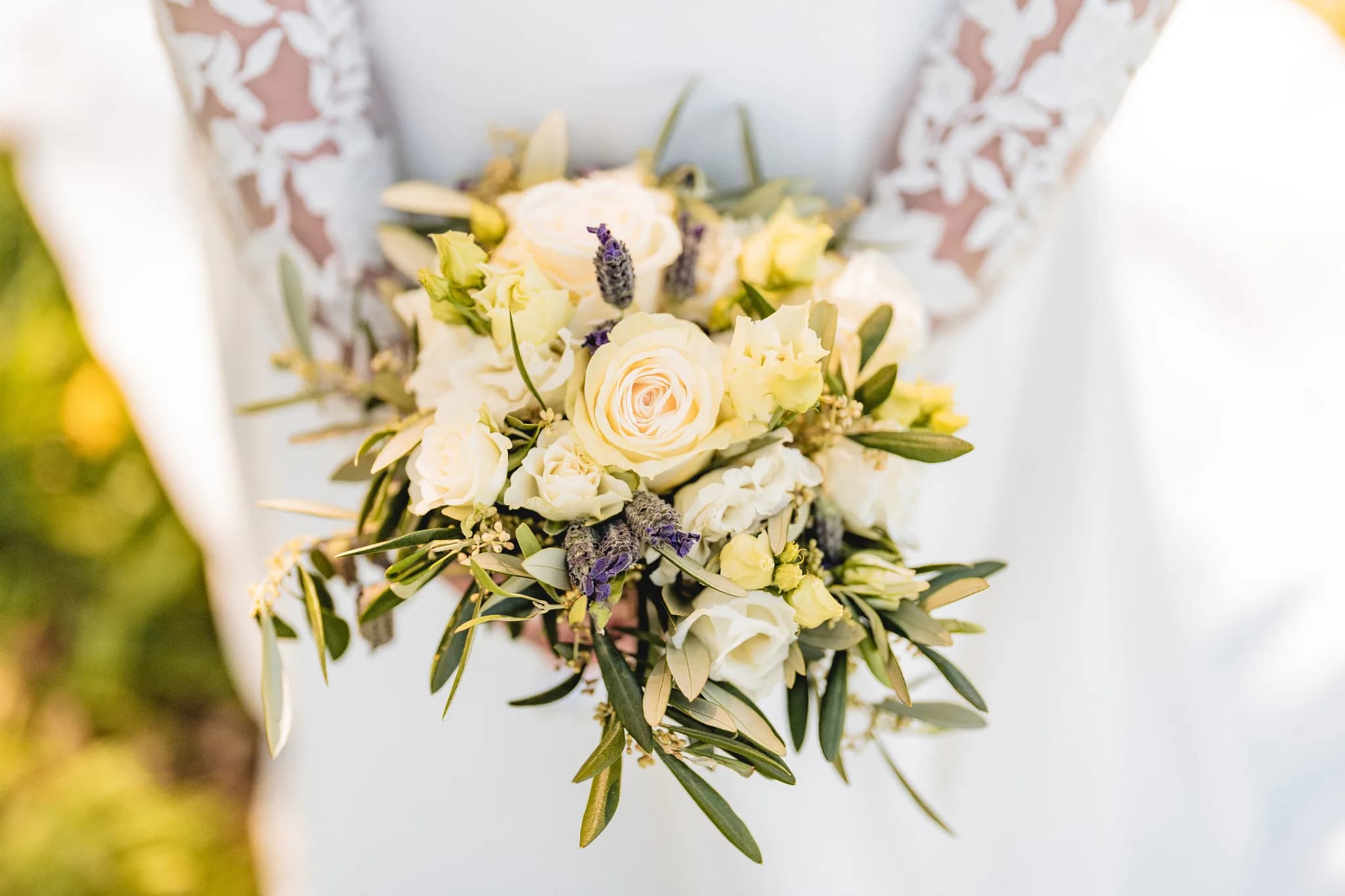 Braut hält bei ihrer freien Trauung in der Rhön einen sommerlichen Blumenstrauß mit hellen Rosen und Lavendel.