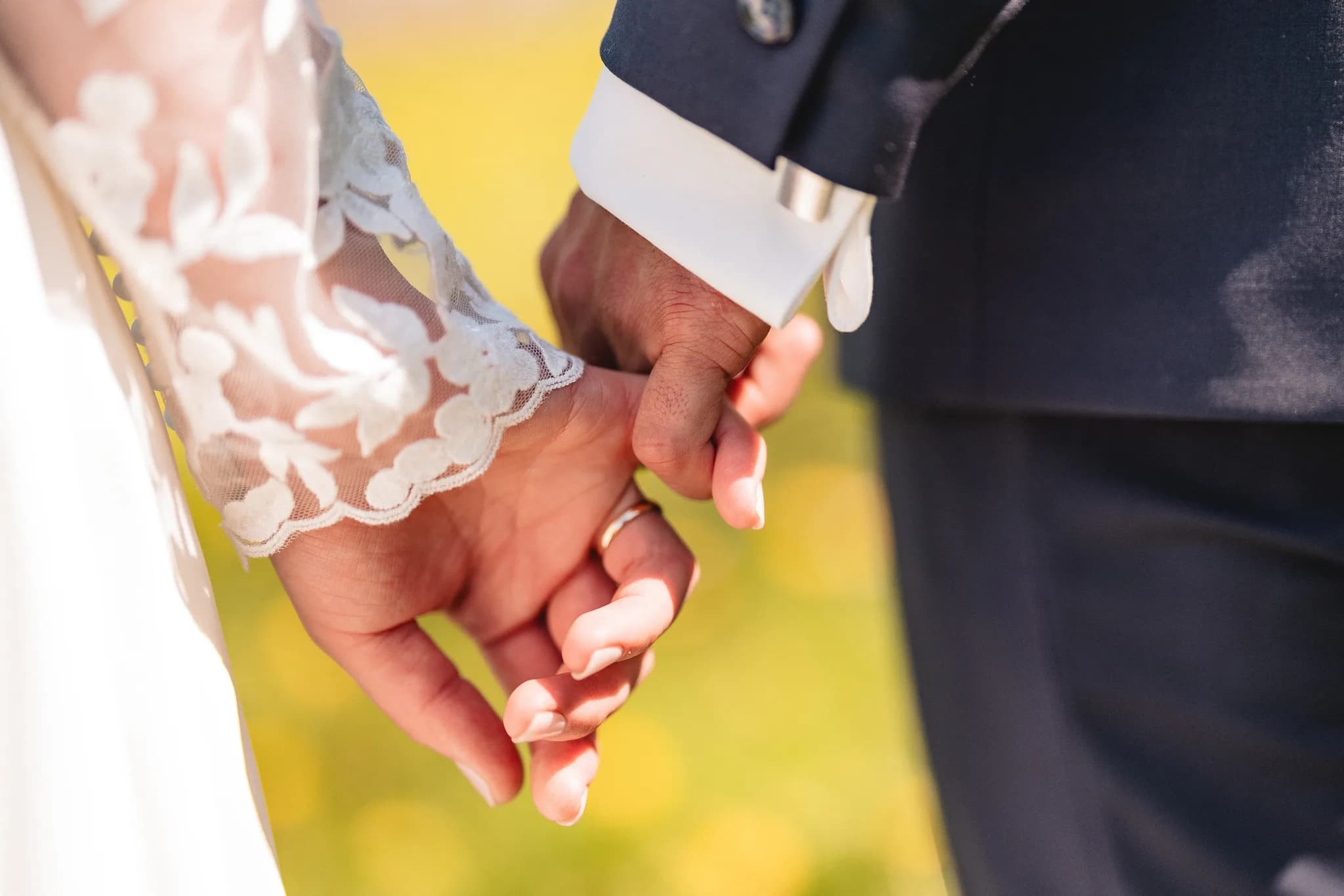 Stefanie und Ralf halten sich bei ihrer Hochzeit an der Ulstermühle in der Rhön innig an den Händen.