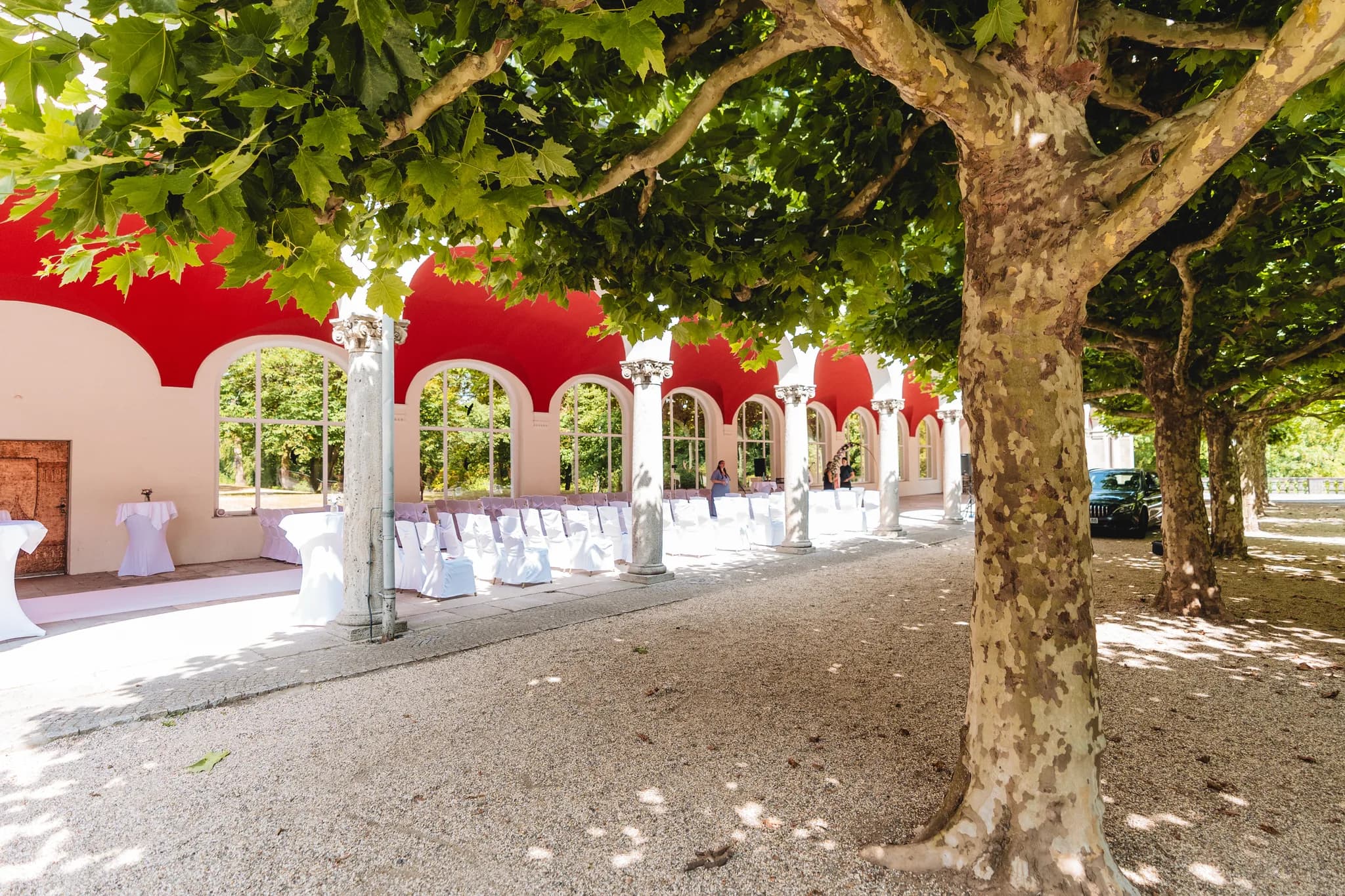 Festlich bestuhlte Hochzeitslocation unter einer Baumallee am Dolce by Wyndham in Bad Nauheim.