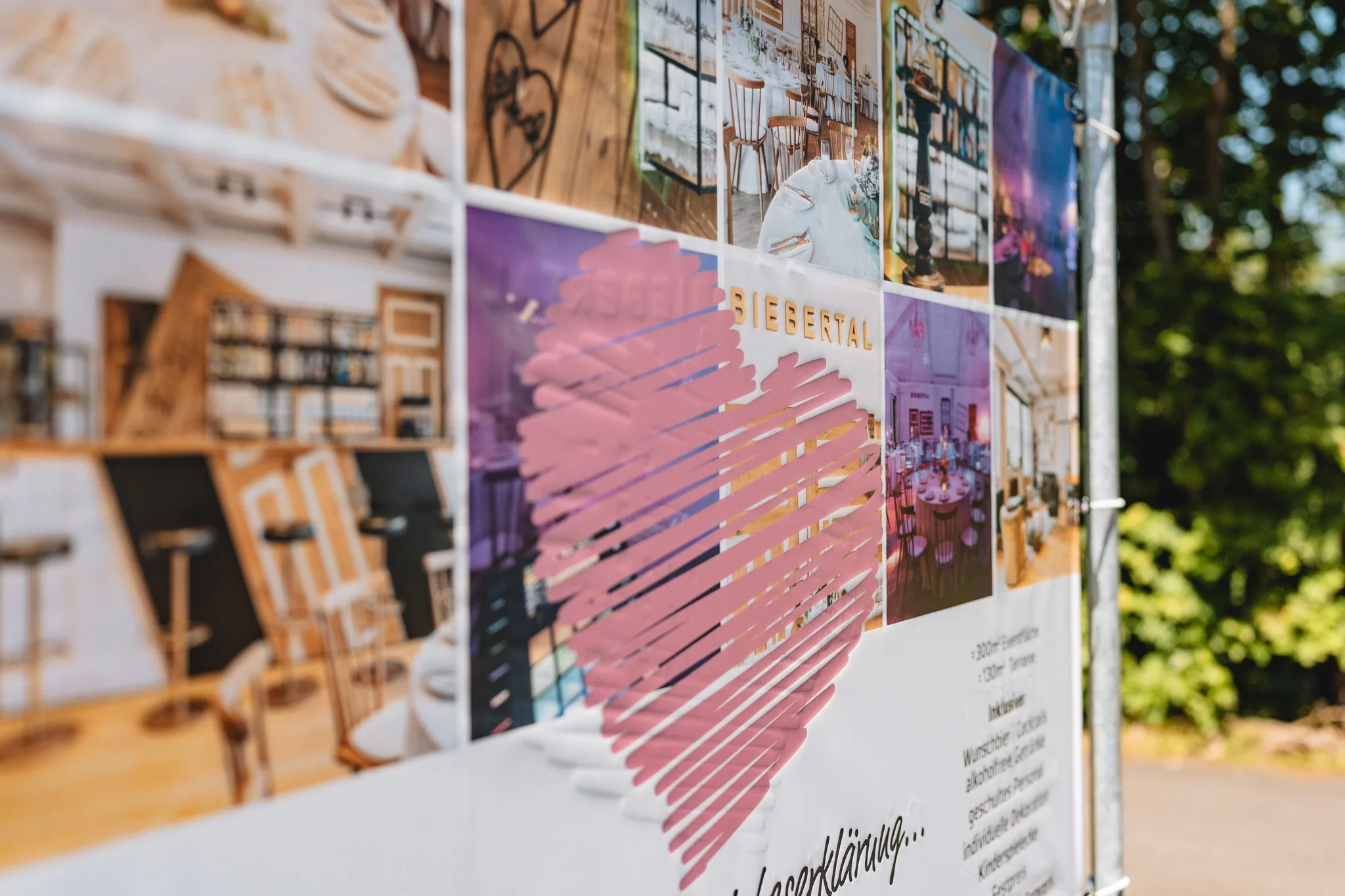 Infotafel mit Hochzeitsfotos und einem großen rosa Herzen als Gestaltungselement für die Location in Hofbieber.