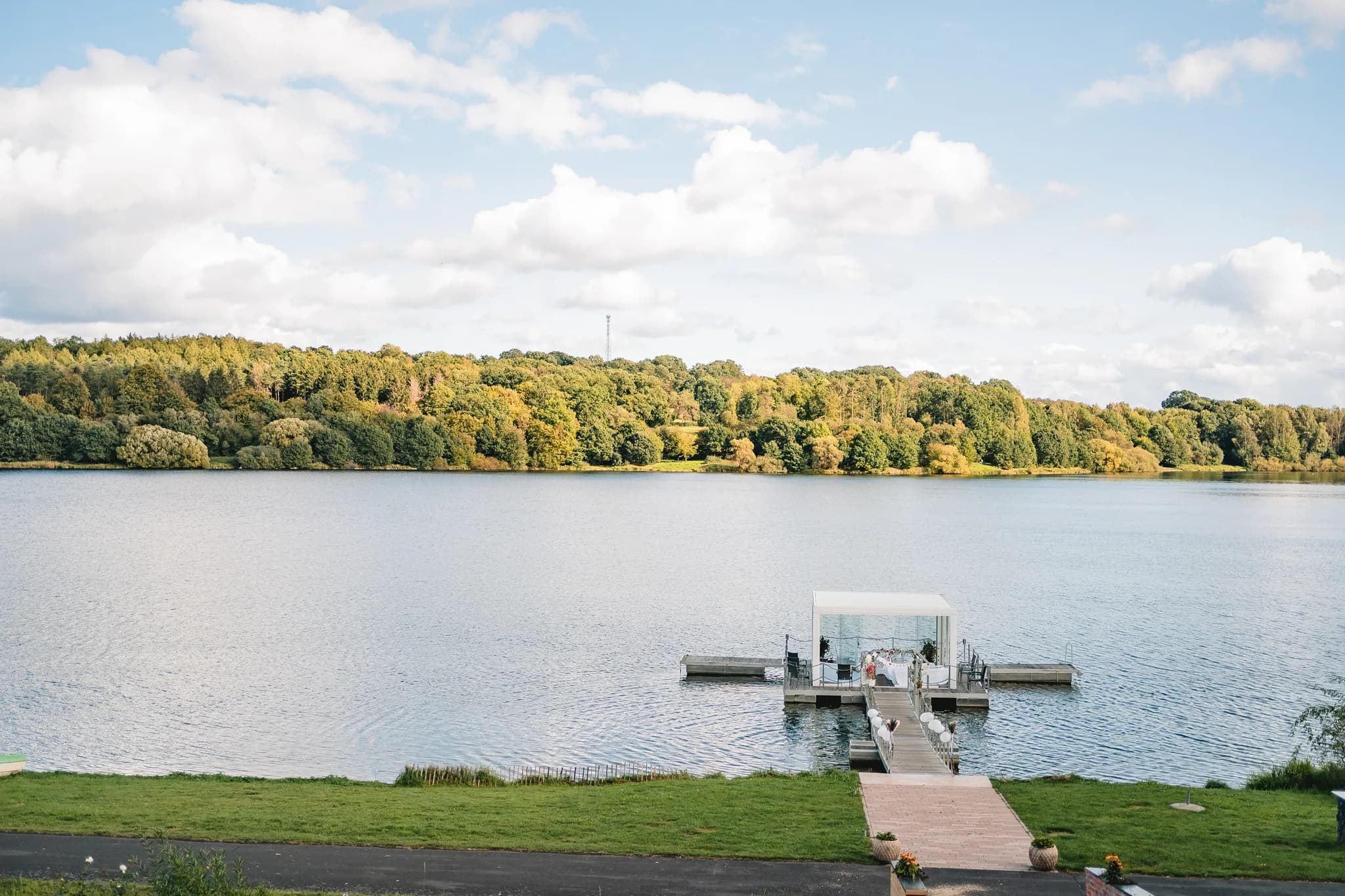 Die Hochzeitslocation am Steg des Lakeside Resort Michaela vor einer malerischen Waldkulisse am See.