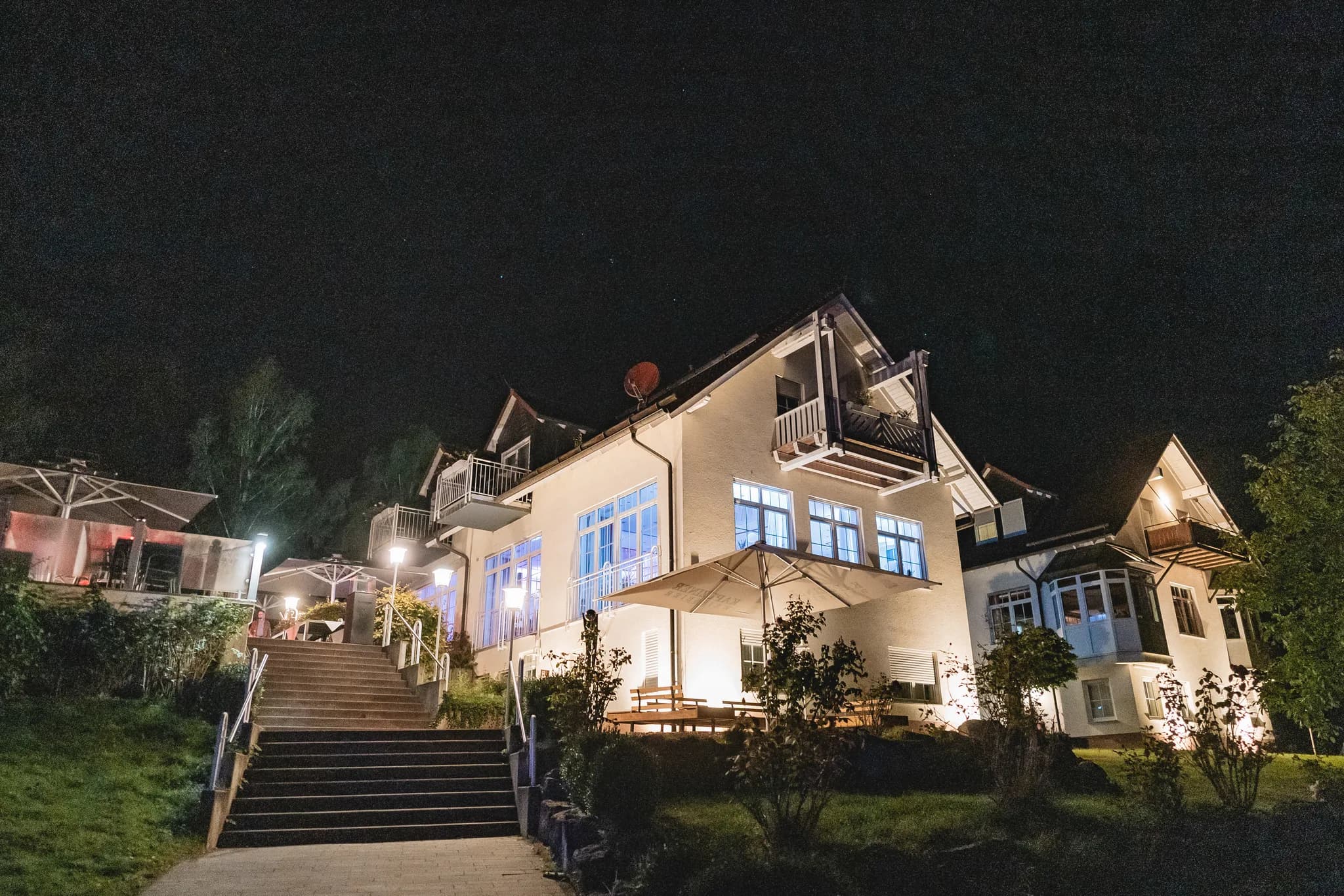 Das Lakeside Resort Michaela bei Nacht mit hell erleuchteter Fassade und beleuchteter Treppe bei einer Hochzeitsfeier.