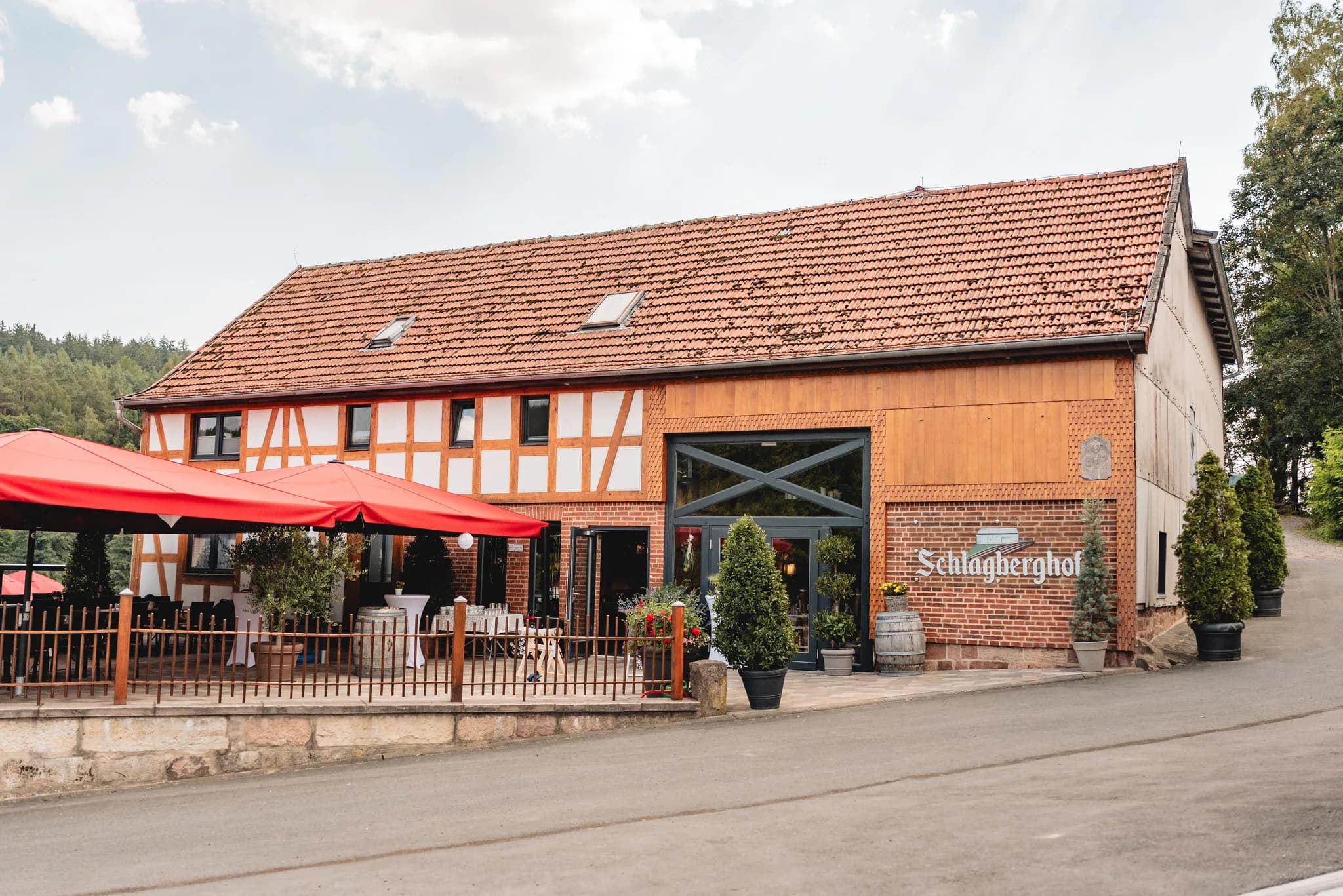 Außenansicht des festlich dekorierten Schlagberghofs in Kleinlüder mit roter Terrasse und Fachwerkfassade.
