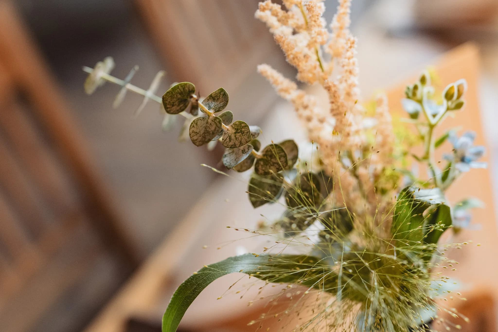Ein filigraner Hochzeitsstrauß mit Eukalyptus und Trockenblumen als florale Tischdekoration bei einer Hochzeit in Kleinlüder.