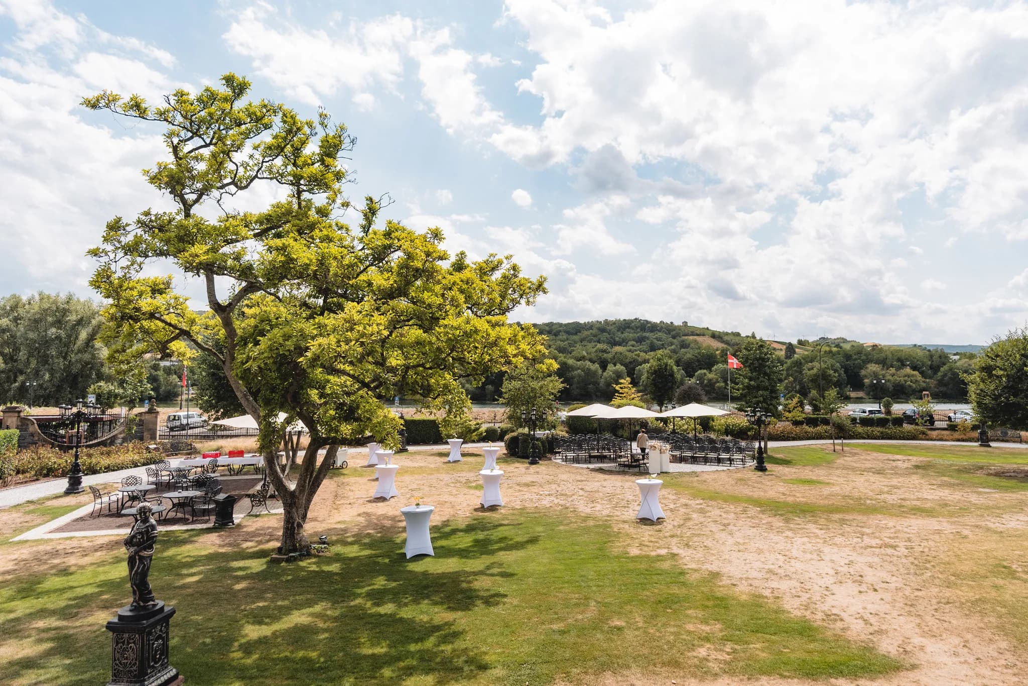 Festlich gedeckte Stehtische und eine Bestuhlung im Freien für eine Hochzeitsfeier an der Mosel in Lieser.