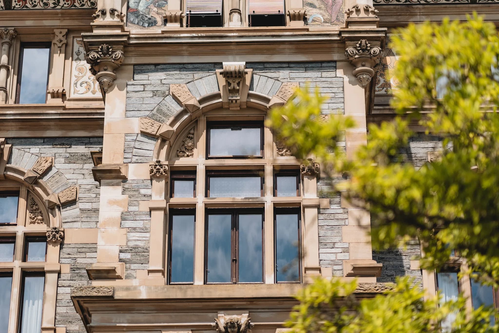 Detailaufnahme der verzierten Steinfassade und der hohen Fenster am Schloss Lieser an der Mosel.