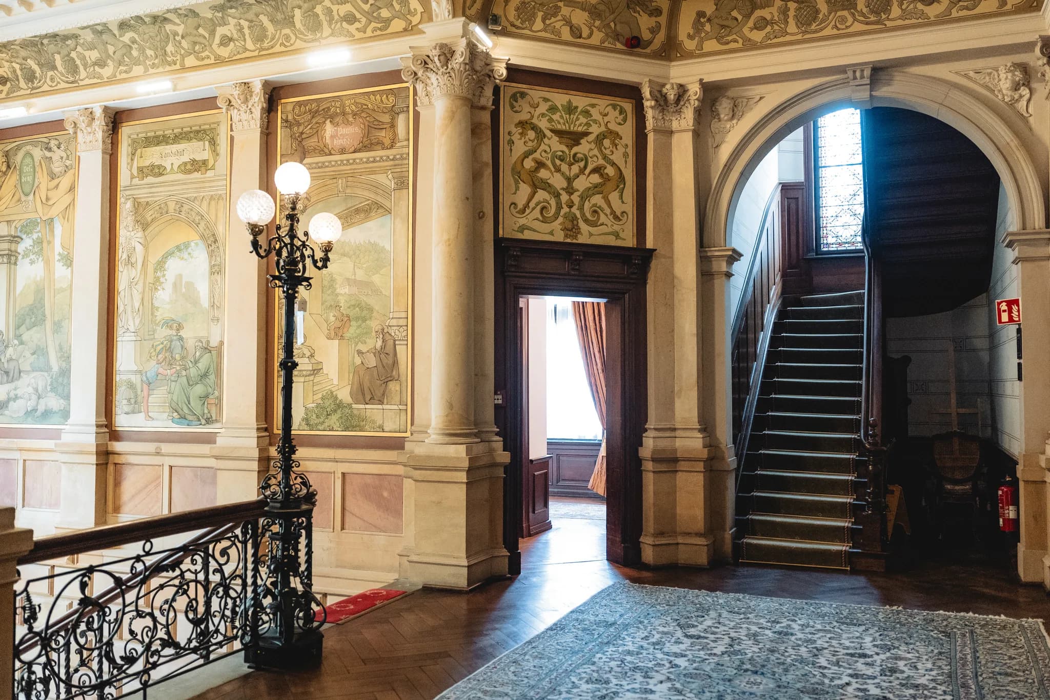 Prachtvoller Treppenaufgang mit historischen Wandmalereien in einem herrschaftlichen Gebäude an der Mosel.