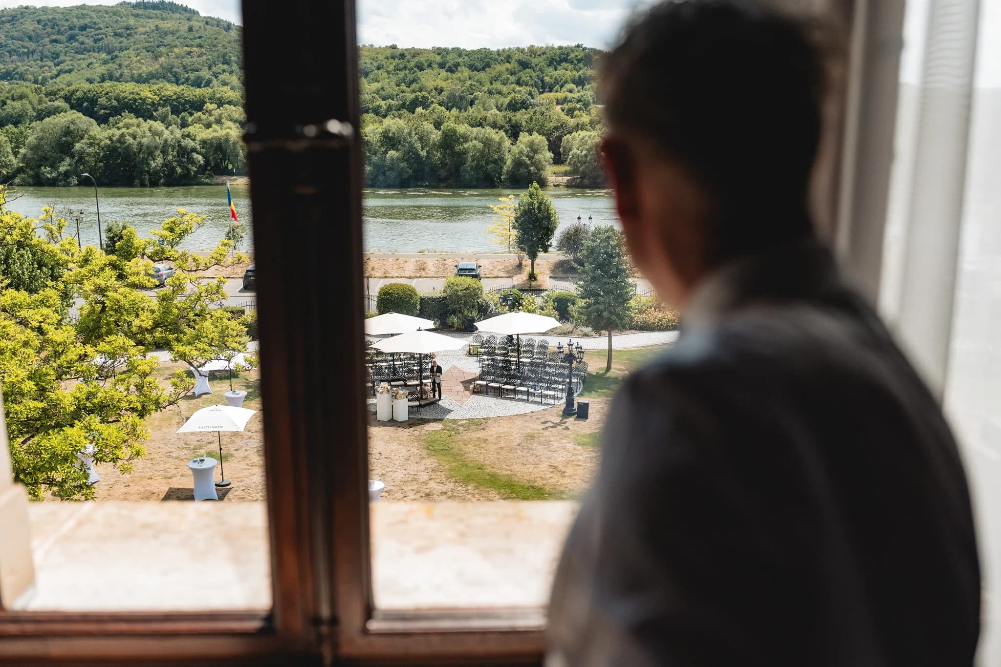 Blick aus einem Fenster auf die vorbereitete Hochzeitslocation an der Mosel in Lieser mit Blick auf den Fluss.