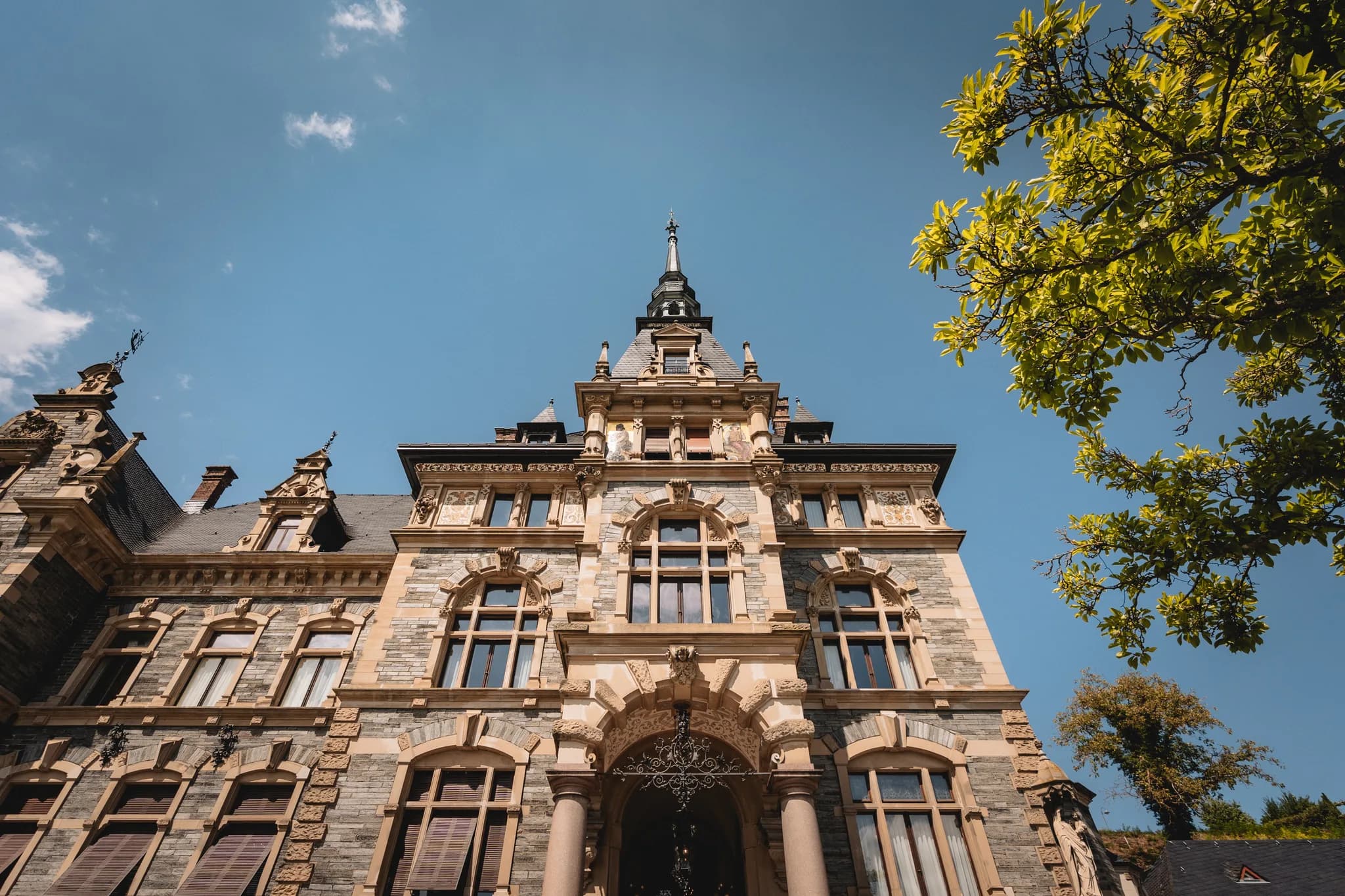 Imposante Fassade des historischen Schlosses Lieser an der Mosel unter strahlend blauem Himmel.