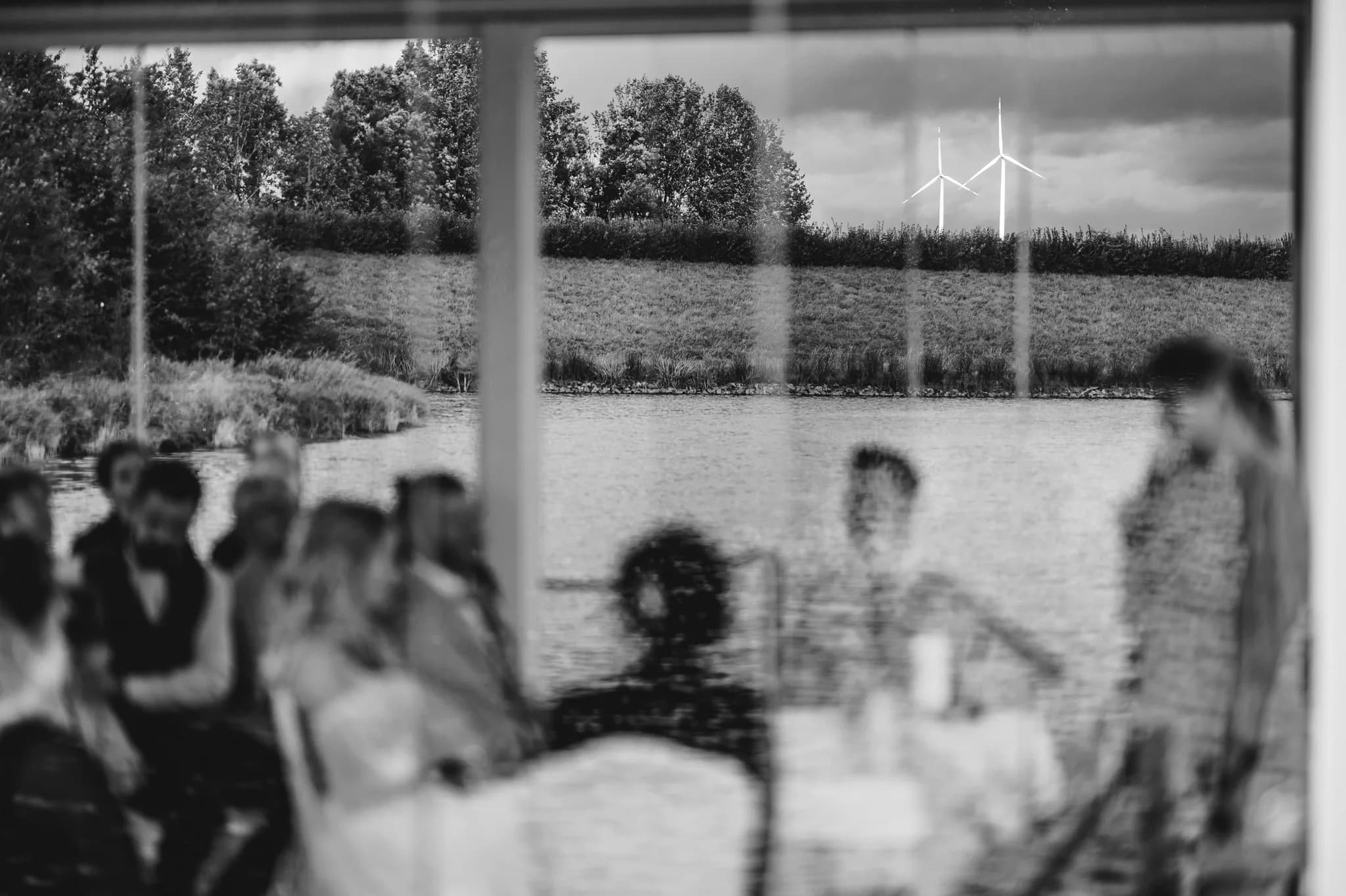 Spiegelung der Hochzeitsgesellschaft von Peggy und Daniel im Fenster mit Blick auf den See am Lakeside Resort.