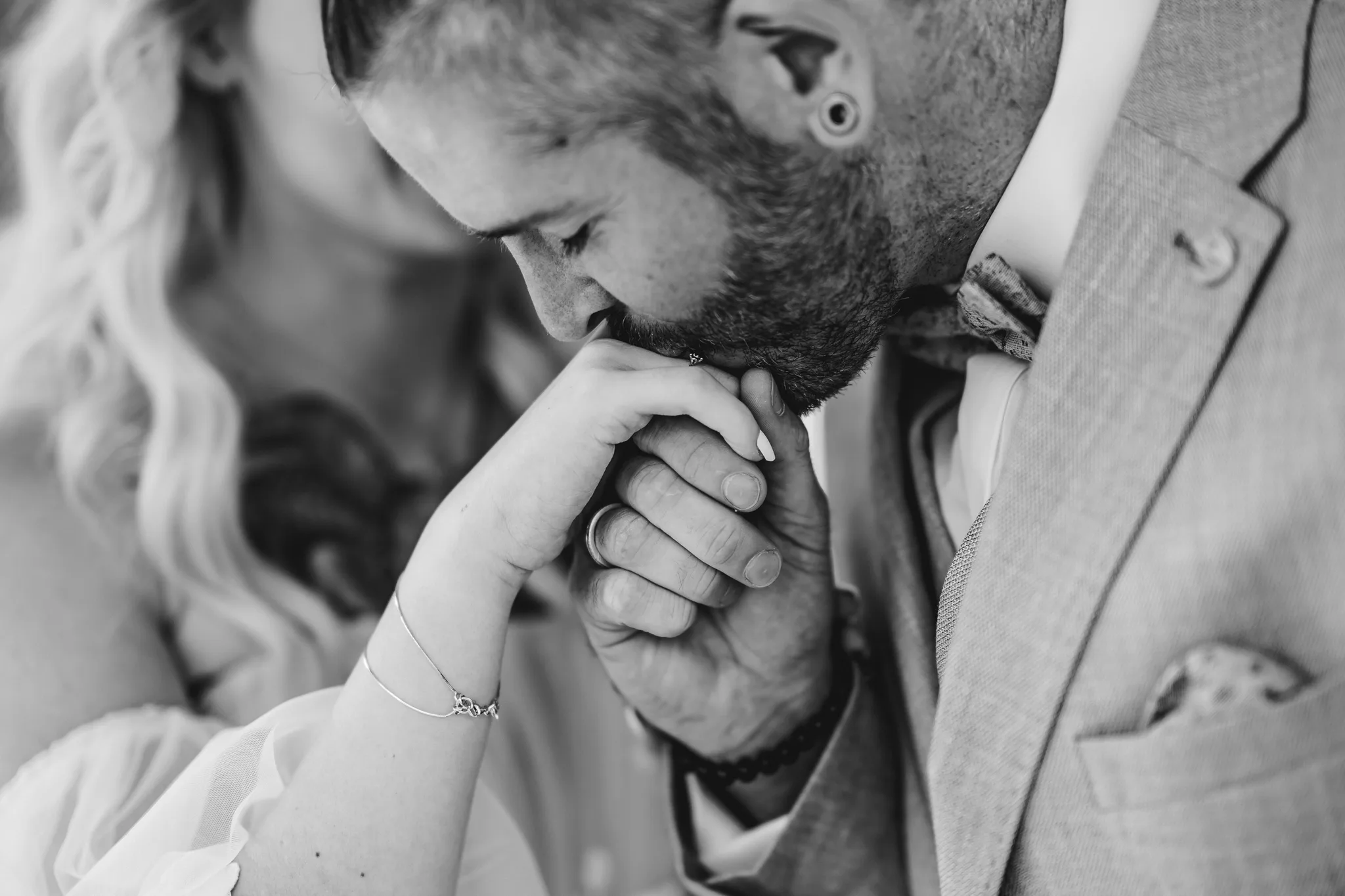 Daniel küsst liebevoll die Hand von Peggy während ihrer Hochzeit im Lakeside Resort Michaela.