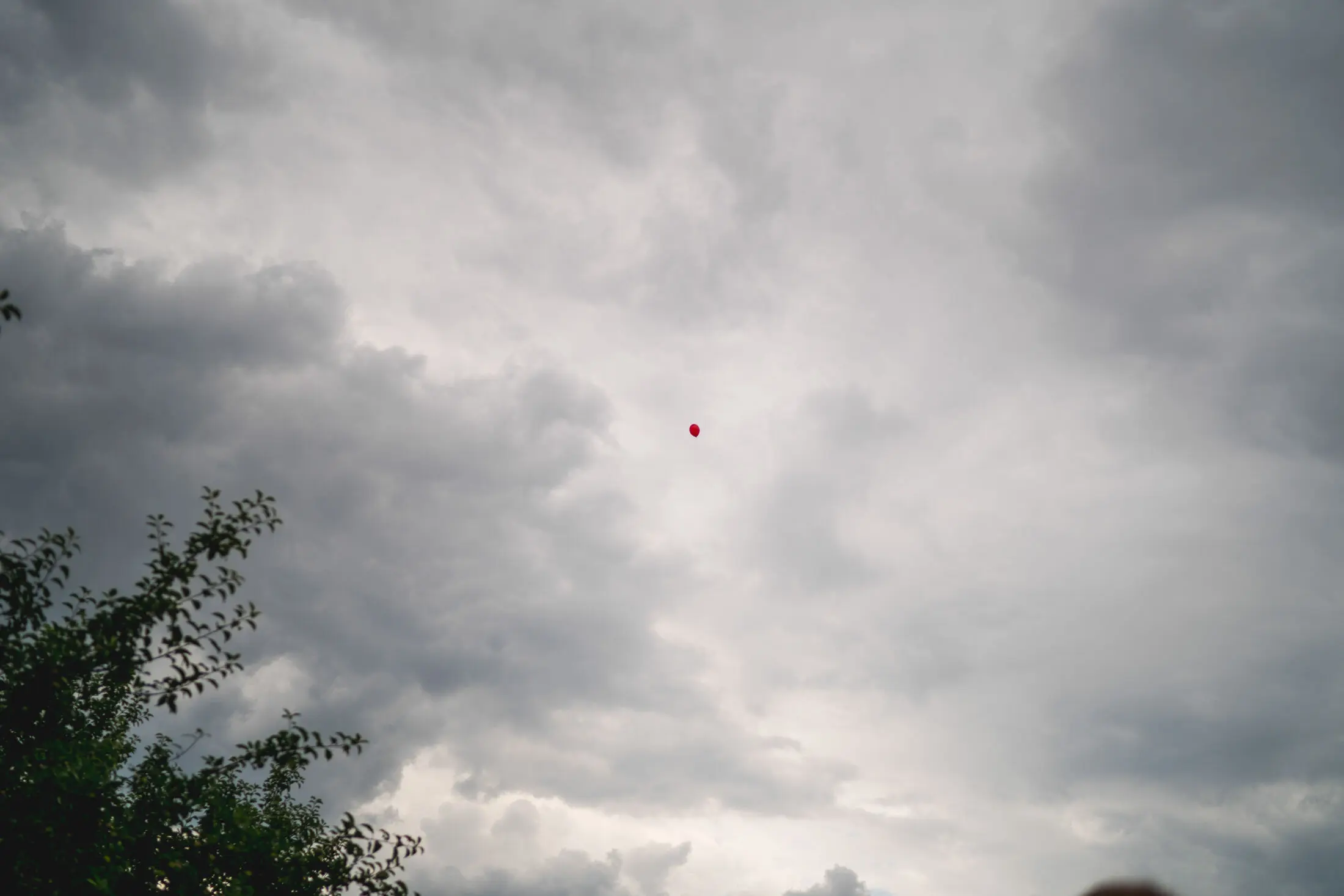 Schlechtes Wetter auf der Hochzeit, roter Ballon.
